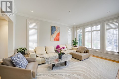 A living room with a beige couch, a coffee table, and a painting on the wall.