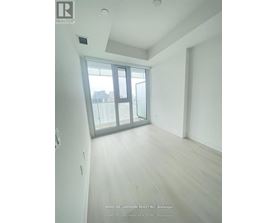 A room with a sliding glass door and wooden flooring.