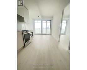 A spacious kitchen with white cabinets and a stainless steel oven.