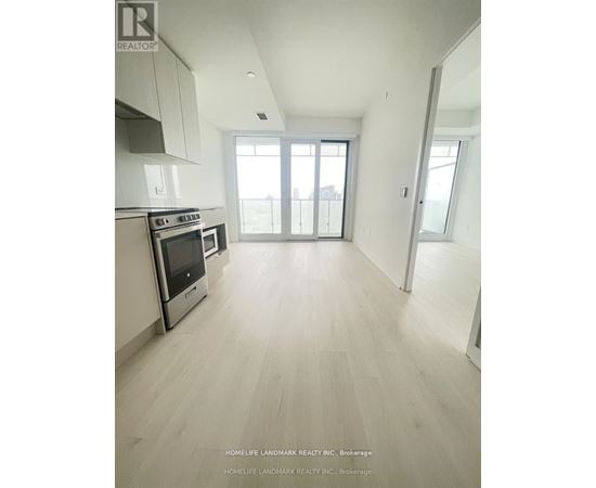A spacious kitchen with white cabinets and a stainless steel oven.