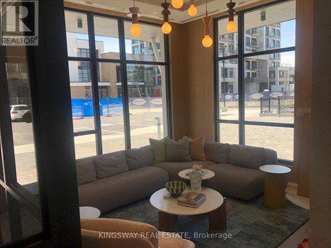 A living room with a couch and a table with a vase on it.
