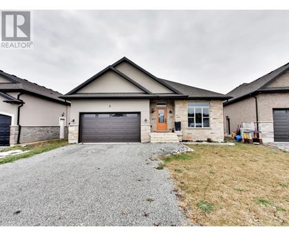 A house with a gravel driveway in front of it.