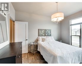 A bedroom with a white bed and a chandelier hanging from the ceiling.