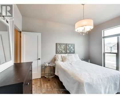 A bedroom with a white bed and a chandelier hanging from the ceiling.