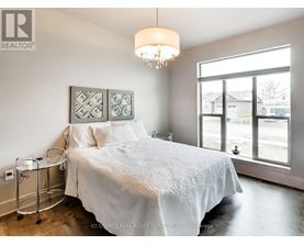 A bedroom with a large bed and a chandelier.