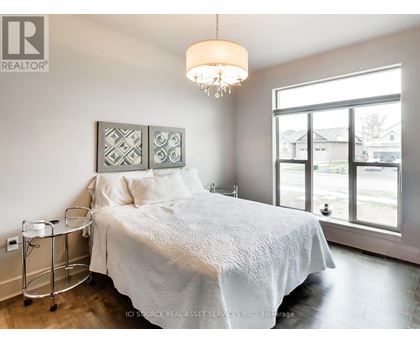 A bedroom with a large bed and a chandelier.