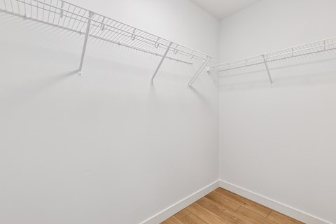 Empty room with a white wall and a metal rack.