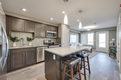 A modern kitchen with a large island and stainless steel appliances.