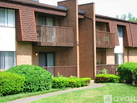 Apartment building with green bushes in front.