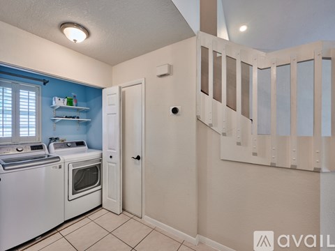 A kitchen with a washing machine and dryer in it.