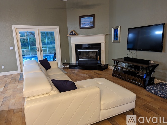 A living room with a white couch and a fireplace.