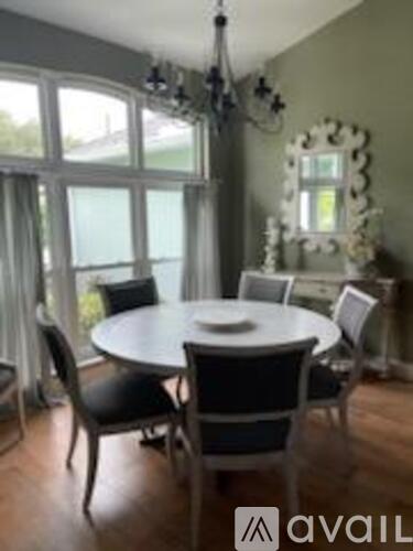 A dining room with a round table and chairs.
