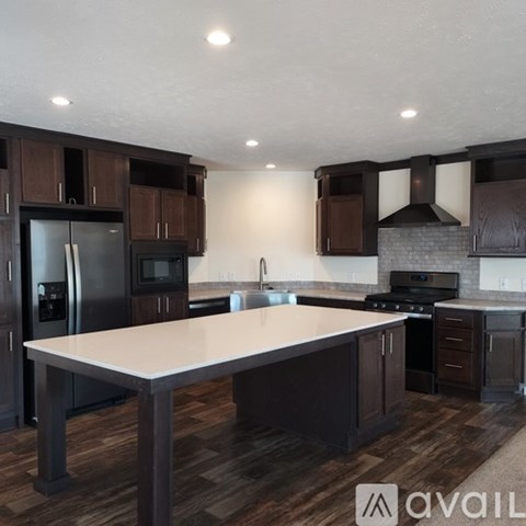 A modern kitchen with dark wood cabinets and a large island.