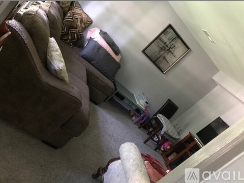 A living room with a brown couch and a white chair.