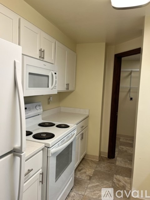 A kitchen with white appliances and cabinets.