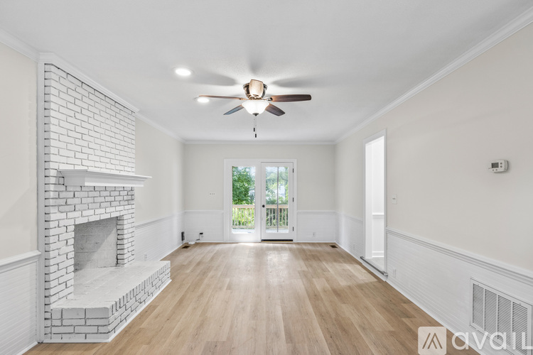 A spacious room with a fireplace and a ceiling fan.