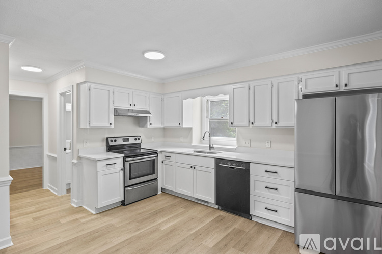 A kitchen with white cabinets and appliances.