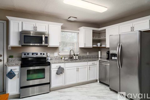 A kitchen with white cabinets and stainless steel appliances.