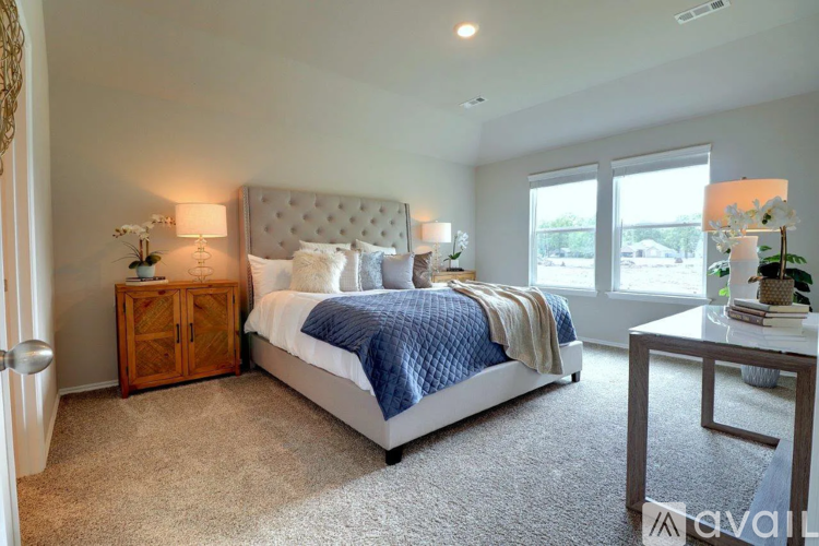 A bedroom with a large bed, a wooden cabinet, and a carpeted floor.