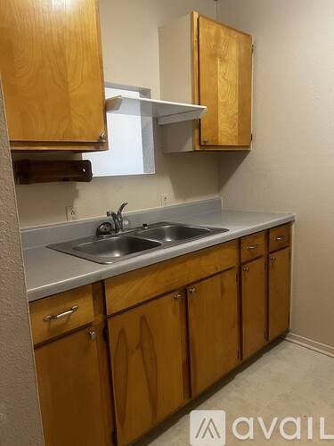 A kitchen with wooden cabinets and a stainless steel sink.