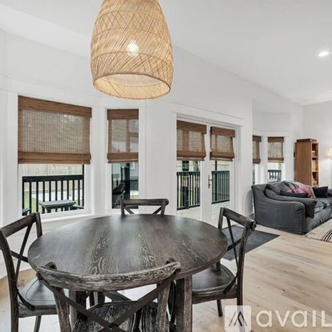 A dining room with a round wooden table and chairs.