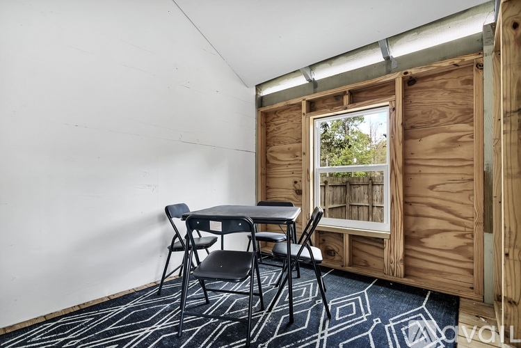 A room with a table and chairs and a window.