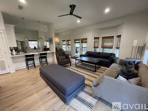 A living room with a grey couch and a black ottoman.