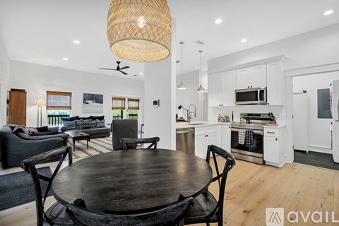 A modern kitchen with a dining table and chairs in the foreground.
