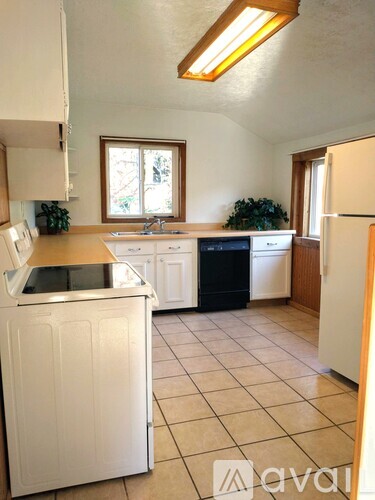 A kitchen with white cabinets and a black dishwasher.