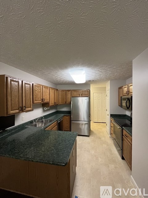 A kitchen with wooden cabinets and granite countertops.