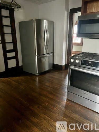 A kitchen with a stainless steel refrigerator, microwave, and oven.