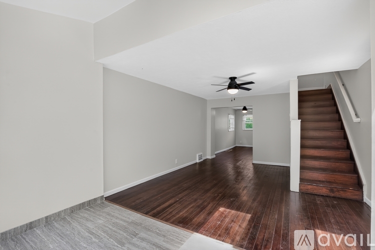 A spacious room with a staircase leading to the upper floor.