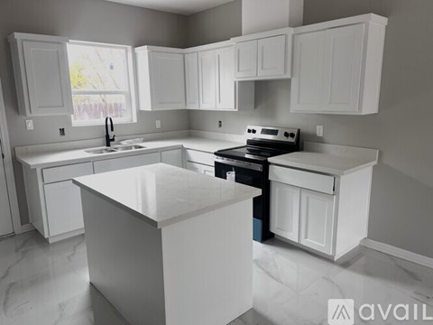 A kitchen with white cabinets and appliances.