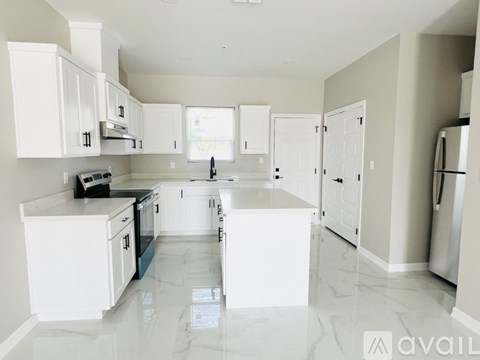 A kitchen with white cabinets and appliances.