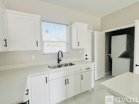 A kitchen with white cabinets and a sink.