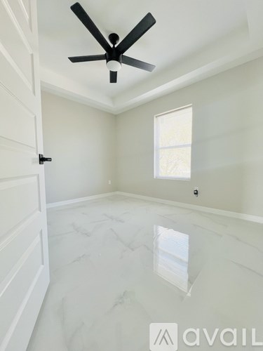 A room with a ceiling fan and a window.