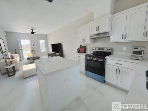 A modern kitchen with white cabinets and a blue oven.