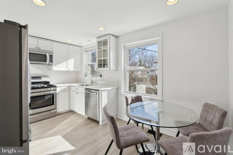 A modern kitchen with a glass table and chairs.