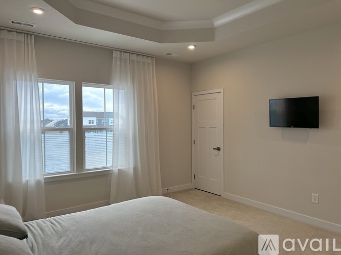 A bedroom with a large bed and a flat screen TV mounted on the wall.