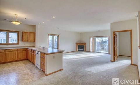 A spacious kitchen with wooden cabinets and a white dishwasher.
