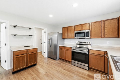 A kitchen with wooden cabinets and stainless steel appliances.