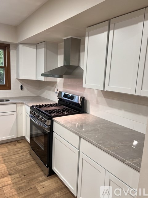 A kitchen with a black stove top oven and white cabinets.