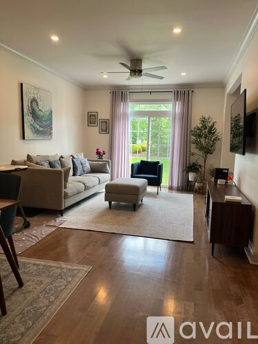 A living room with a couch, chair, and a television.