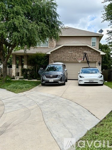 Two cars are parked in front of a house.