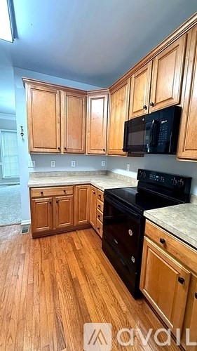 A kitchen with wooden cabinets and black appliances.