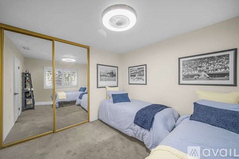 A bedroom with two beds and a mirror on the wall.