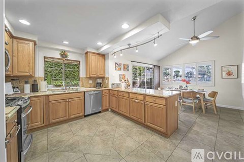 A kitchen with wooden cabinets and a tiled floor.
