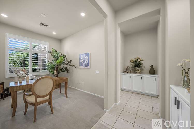 A dining room with a wooden table and chairs.
