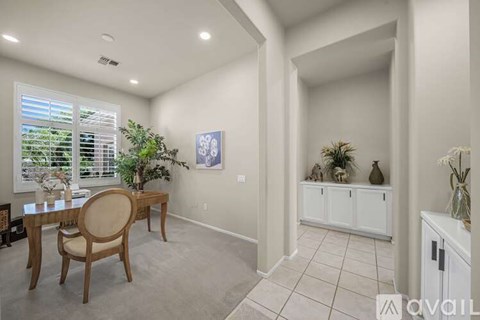 A dining room with a wooden table and chairs.