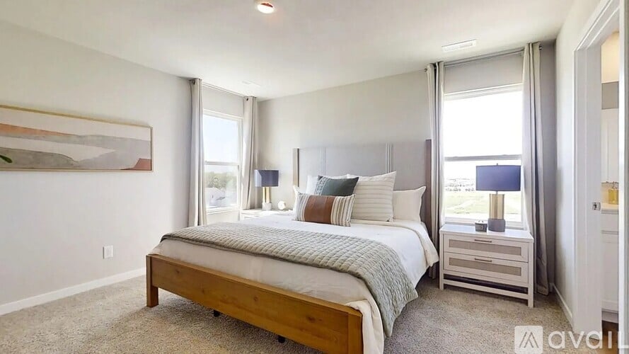 A bedroom with a large bed and a painting on the wall.